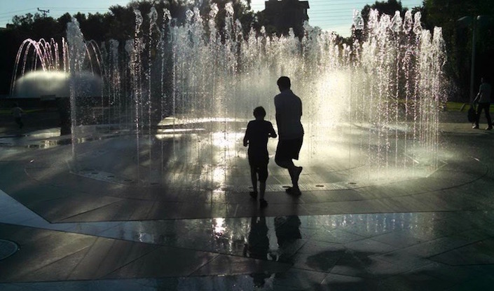 C and his dad playing in a fountain