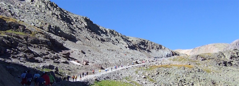 runners heading over a mountain pass