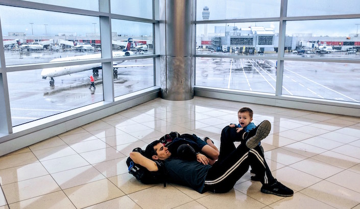 boys laying on the floor in the airport